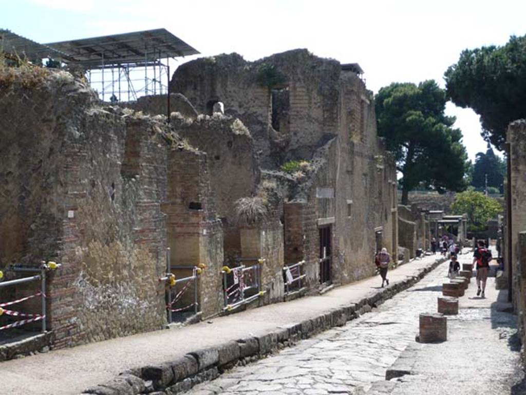 Ins. Orientalis II. on left, Ins. V, on right, Herculaneum. May 2009. Looking south on Cardo V Superiore.  The remains of the brick columns along the edge of the roadway, on right, would have supported a small portico. Photo courtesy of Buzz Ferebee.
According to Maiuri, outside the doorway of V,30 was a little portico along the roadway, and by a stretch of better pavement adorned with marble.
See Maiuri, Amedeo, (1977). Herculaneum. 7th English ed, of Guide books to the Museums Galleries and Monuments of Italy, No.53 (p.50-51).